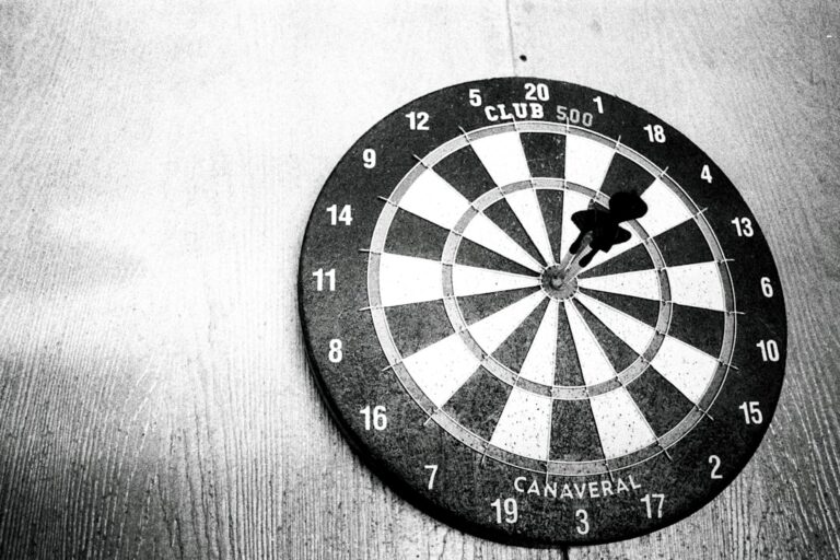 Dartspieler üben konzentriertes Werfen zur Vorbeugung von Dartitis am Dartboard