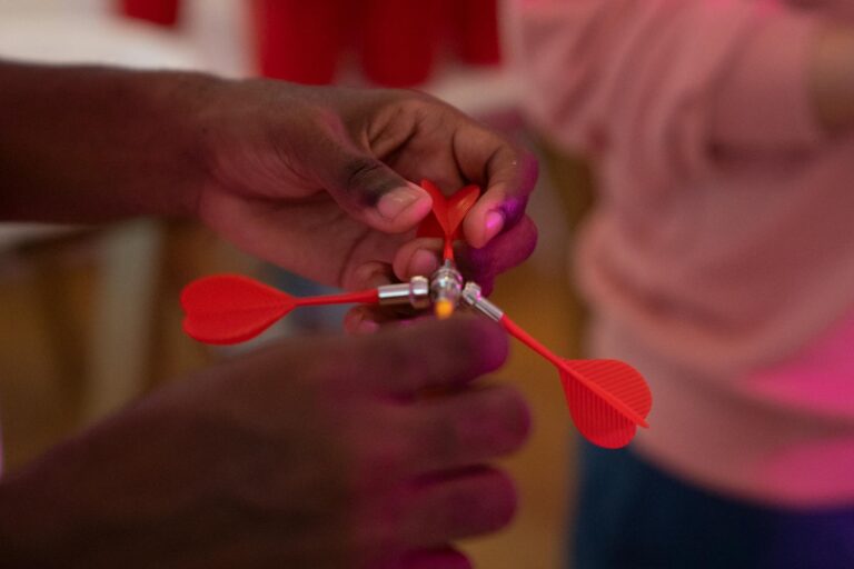 Hand hält Dartpfeil in genauer Griffposition für präzisen Wurf