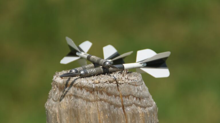 Spieler demonstriert korrekte Armhaltung beim präzisen Dartwurf für bessere Kontrolle