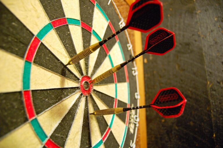 Anfänger üben Dartswurf mit konzentrierter Haltung an Dartscheibe