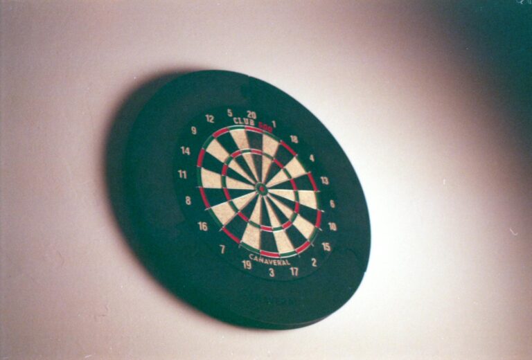 Defekte Dartscheibe mit sichtbaren Schäden und Werkzeug zur Reparatur