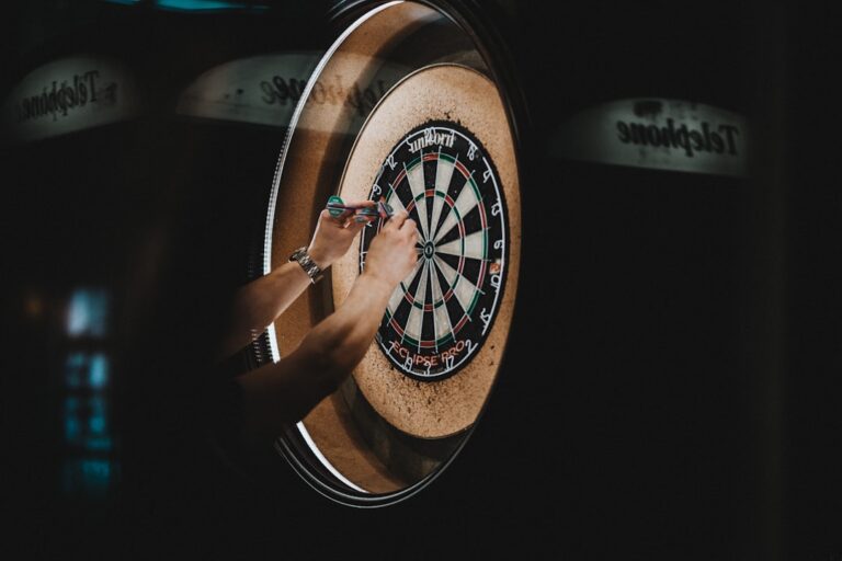 Wie mentales Training im Darts zu besseren Leistungen führt Dartspieler fokussiert beim Wurf durch mentales Training auf der Oche